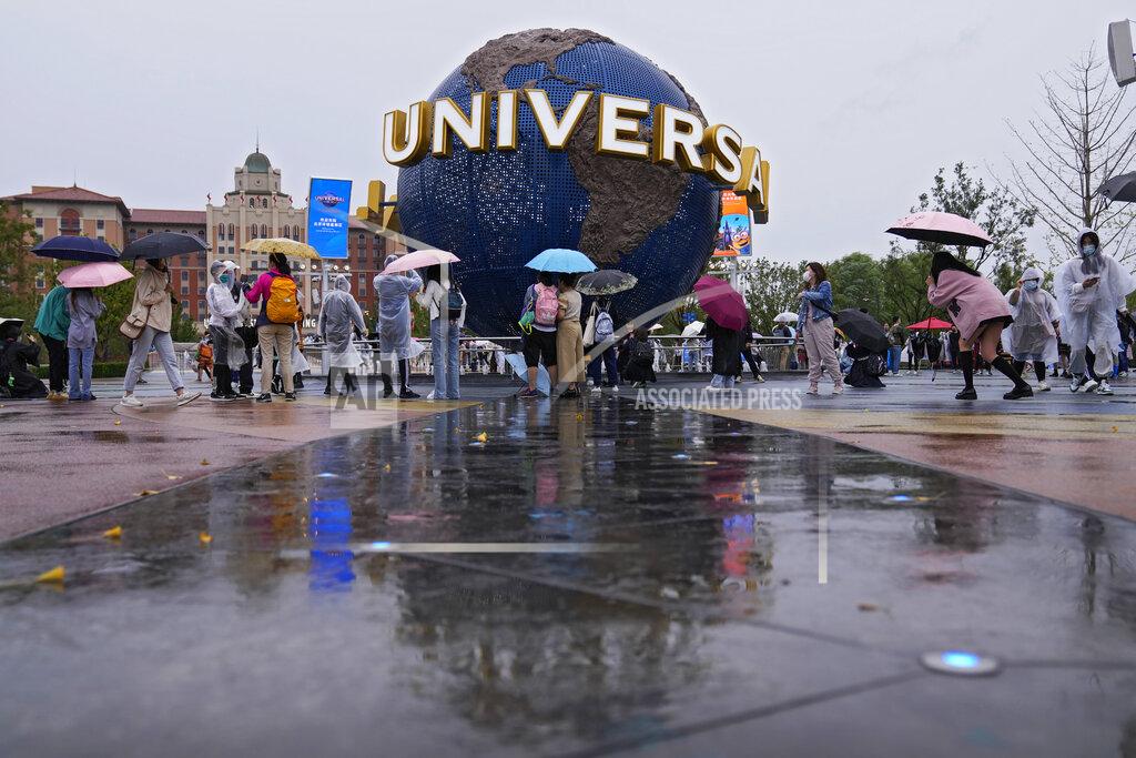 Andy Wong People gather and take selfies in a plaza near the entrance of the Universal Studios Beijing in Beijing, Monday, Sept. 20, 2021. Thousands of people brave the rain visit to the newest location of the global brand of theme parks which officially opens on Monday. (AP Photo/Andy Wong)