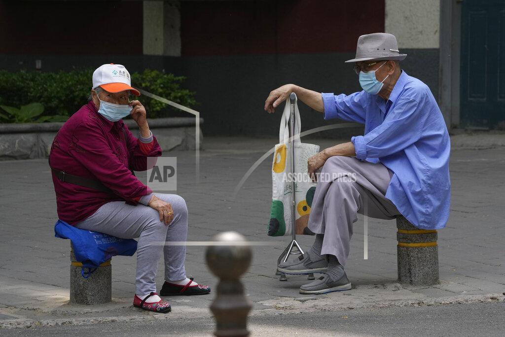 Ng Han Guan Elderly residents wearing mask chat on as street on Monday, May 23, 2022, in Beijing. (AP Photo/Ng Han Guan)
