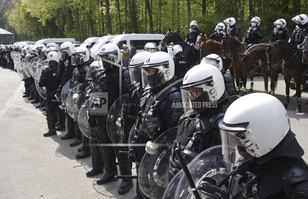 Olivier Matthys Police in riot gear and on horseback form a line at the Bois de la Cambre park during a gathering called "La Boum 2" in Brussels, Saturday, May 1, 2021. Police put on extra patrols Saturday to monitor the gathering which is being held in defiance of Belgium's current COVID-19 regulations. (AP Photo/Olivier Matthys)