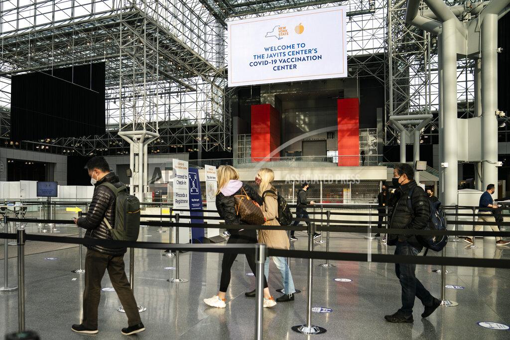 FILE - In this March 31, 2021, file photo, patients arrive for COVID-19 vaccination appointments at the Jacob K. Javits Convention Center in New York. Nearly half of new coronavirus infections nationwide are in just five states, including New York — a situation that puts pressure on the federal government to consider changing how it distributes vaccines by sending more doses to hot spots. (AP Photo/John Minchillo, File)