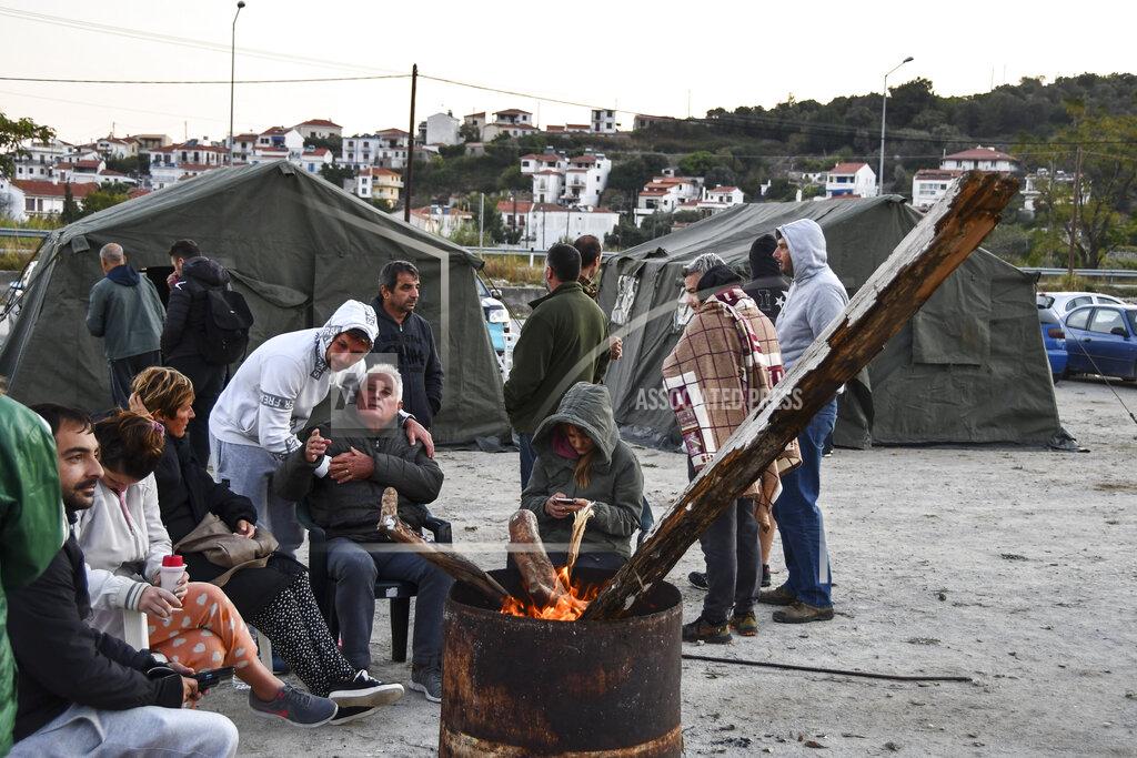 Michael Svarnias Locals sit around a fire near tents after an earthquake, at the village of Kokkari on the eastern Aegean island of Samos, Greece, Saturday, Oct. 31, 2020. A strong earthquake struck in the Aegean Sea between the Turkish coast and the Greek island of Samos, forcing people to live outside in fear of aftershocks. (AP Photo/Michael Svarnias)