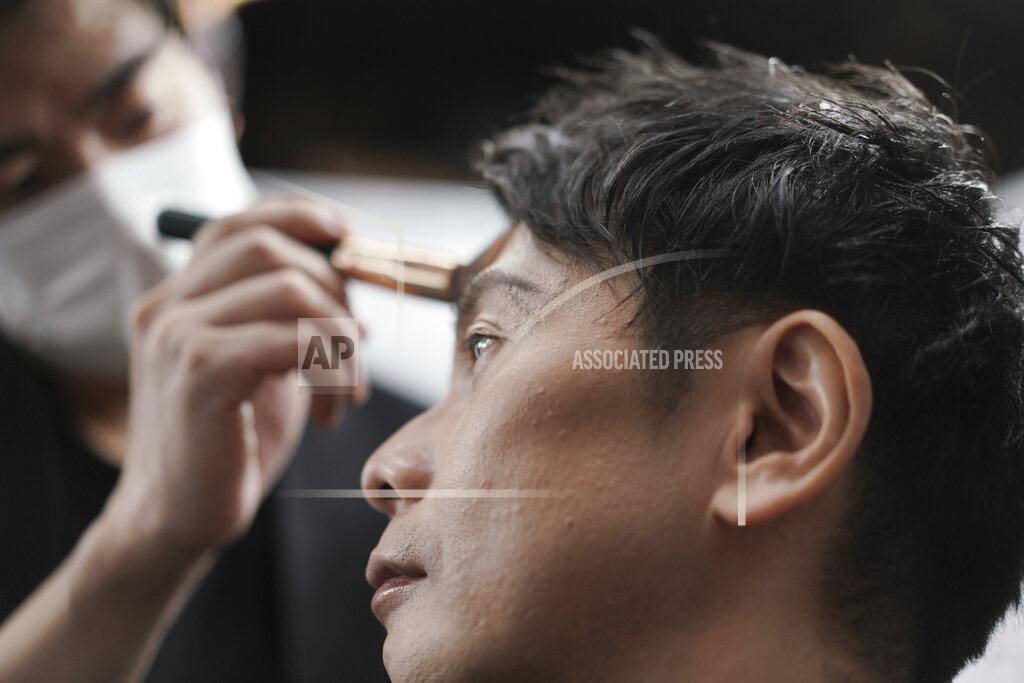Eugene Hoshiko Yoshihiro Kamichi, a 44-year-old office worker, receives makeup and gets his hair done by a makeup artist at Ikemen-Works, a makeup salon for men, in Tokyo Wednesday, Feb. 3, 2021. The coronavirus pandemic has been pushing businesses to the edge in Japan, but some in the men's beauty industry have seen an unexpected expansion in their customer base. Japanese businessmen in their 40s, 50s and 60s who had little interest in cosmetics before the pandemic are now buying makeup. (AP Photo/Eugene Hoshiko)