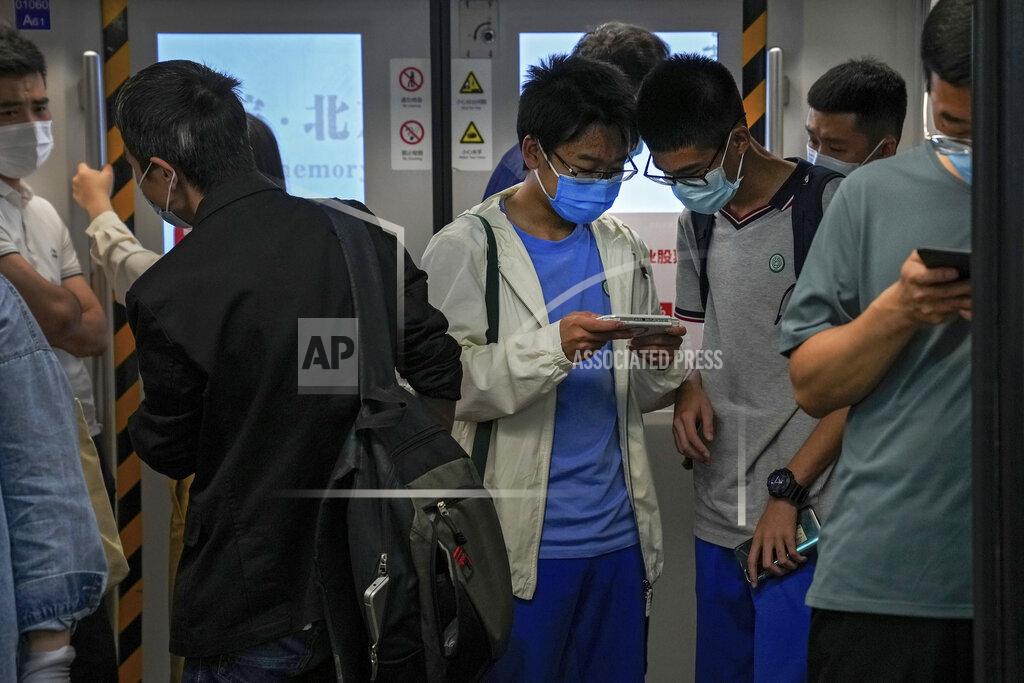 Andy Wong Students play online games inside a subway train in Beijing Tuesday, Sept. 14, 2021. China has set new rules limiting the amount of time kids can spend playing online games. (AP Photo/Andy Wong)