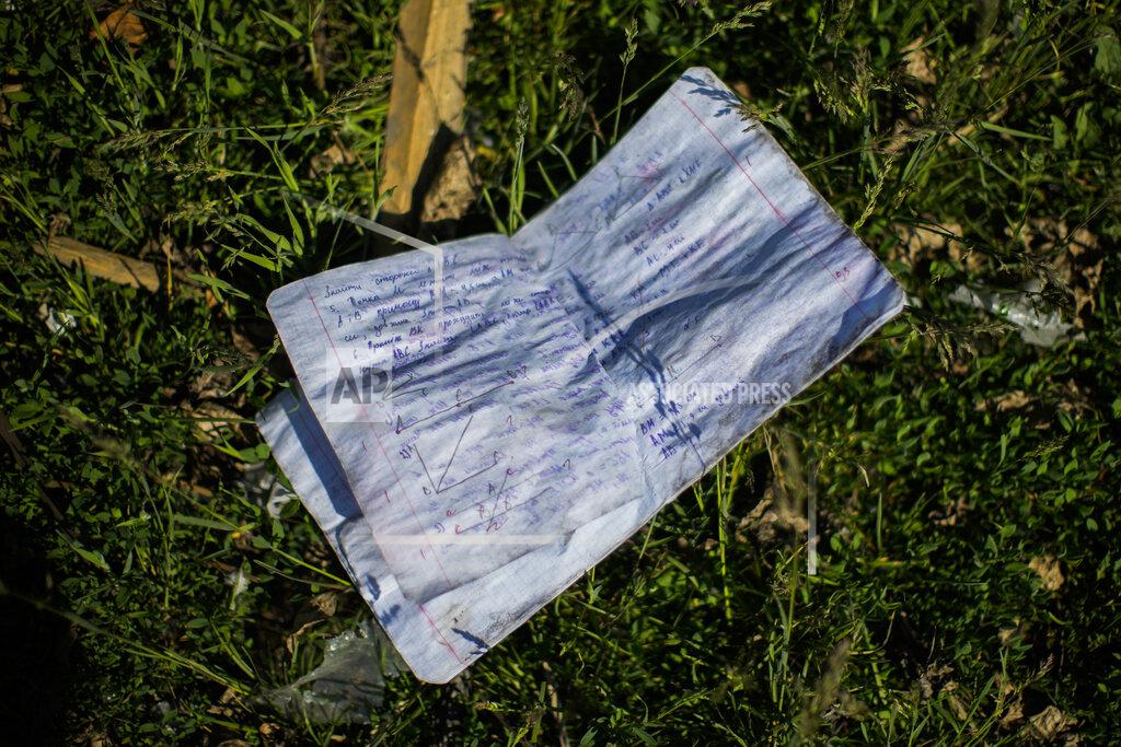 Francisco Seco A student notebook lies on the ground next to a school destroyed in a Russian bombing in Bakhmut, eastern Ukraine, Tuesday, May 24, 2022. The town of Bakhmut has been coming under increasing artillery strikes, particularly over the last week, as Russian forces try to press forward to encircle the city of Sieverodonetsk to the northeast. (AP Photo/Francisco Seco)