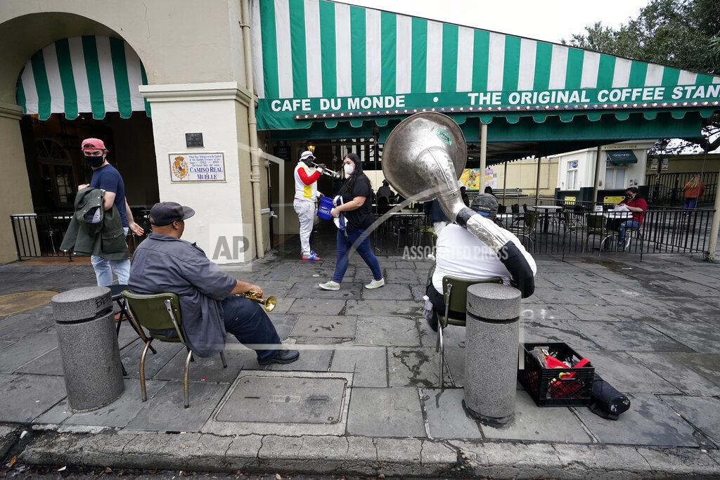 Gerald Herbert Street musicians play outside Cafe du Monde in the French Quarter in New Orleans, Wednesday, Oct. 28, 2020. Businesses that were boarded up for previous hurricanes this season remain open this time as Hurricane Zeta approaches, expected to make landfall as a category 2 hurricane in the afternoon. (AP Photo/Gerald Herbert)
