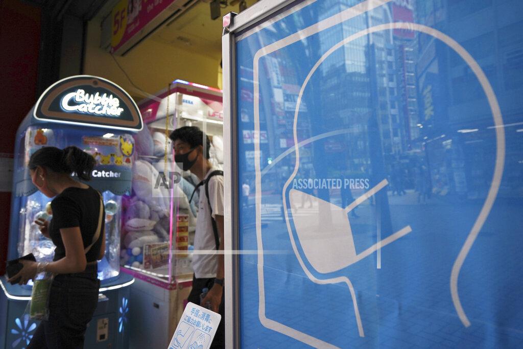 Eugene Hoshiko A sign to wear a protective mask to help curb the spread of the new coronavirus is seen at the entrance to a game center in Tokyo Friday, June 26, 2020. Japan lifted a seven-week pandemic state emergency in late May, and social and business activity have since largely resumed. (AP Photo/Eugene Hoshiko)