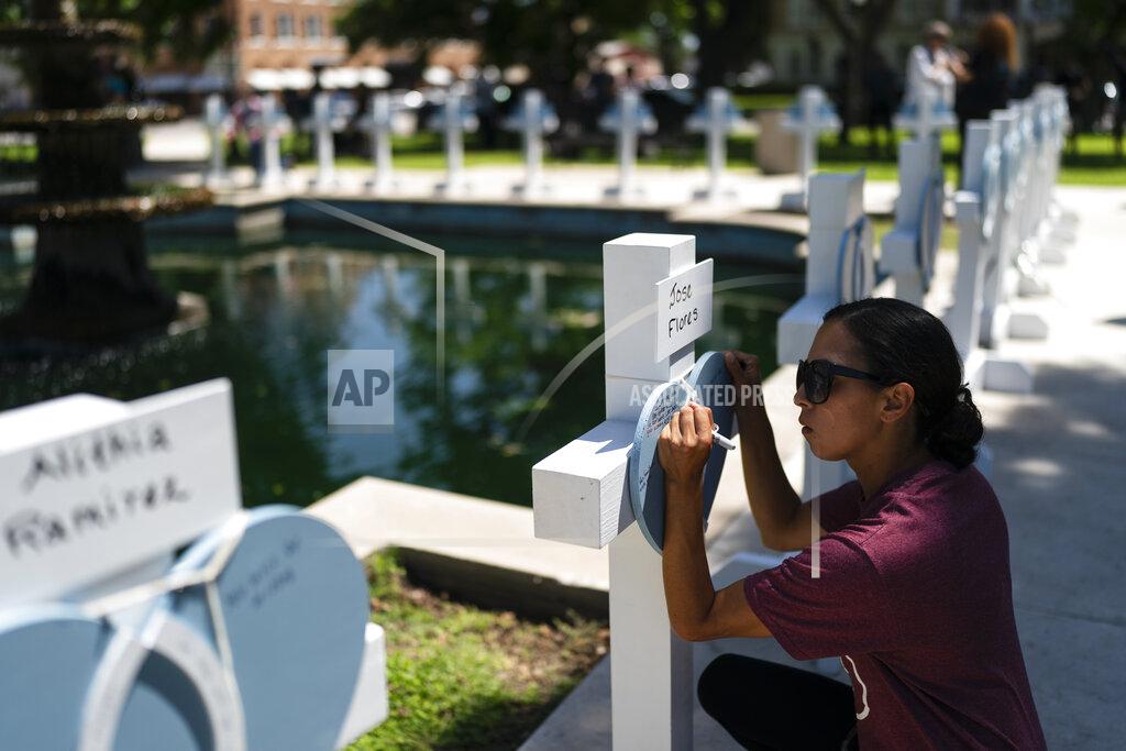 Jae C. Hong A women, who declined to give her name, writes a message at a memorial site for Jose Flores, one of the Robb Elementary School shooting victims, in Uvalde, Texas, Thursday, May 26, 2022. (AP Photo/Jae C. Hong)