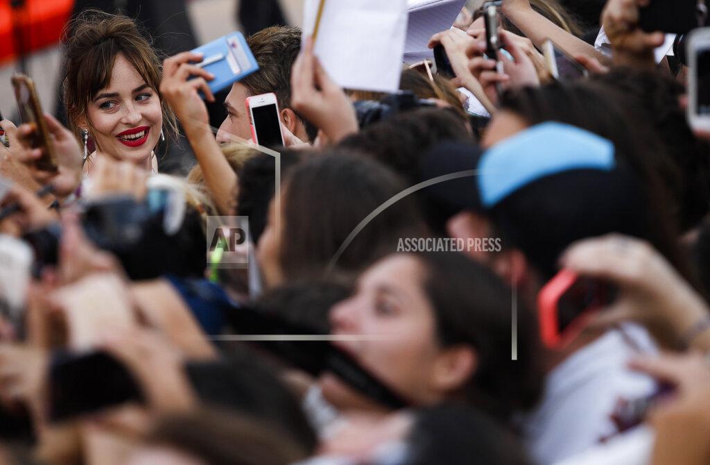 Domenico Stinellis File - Actress Dakota Johnson poses for her fans as she arrives at the Venice Film Festival. The 77th Venice Film Festival will kick off on Wednesday, Sept. 2, 2020, but this year's edition will be unlike any others. Coronavirus restrictions will mean fewer Hollywood stars, no crowds interacting with actors and other virus safeguards will be deployed. (AP Photo/Domenico Stinellis, File)