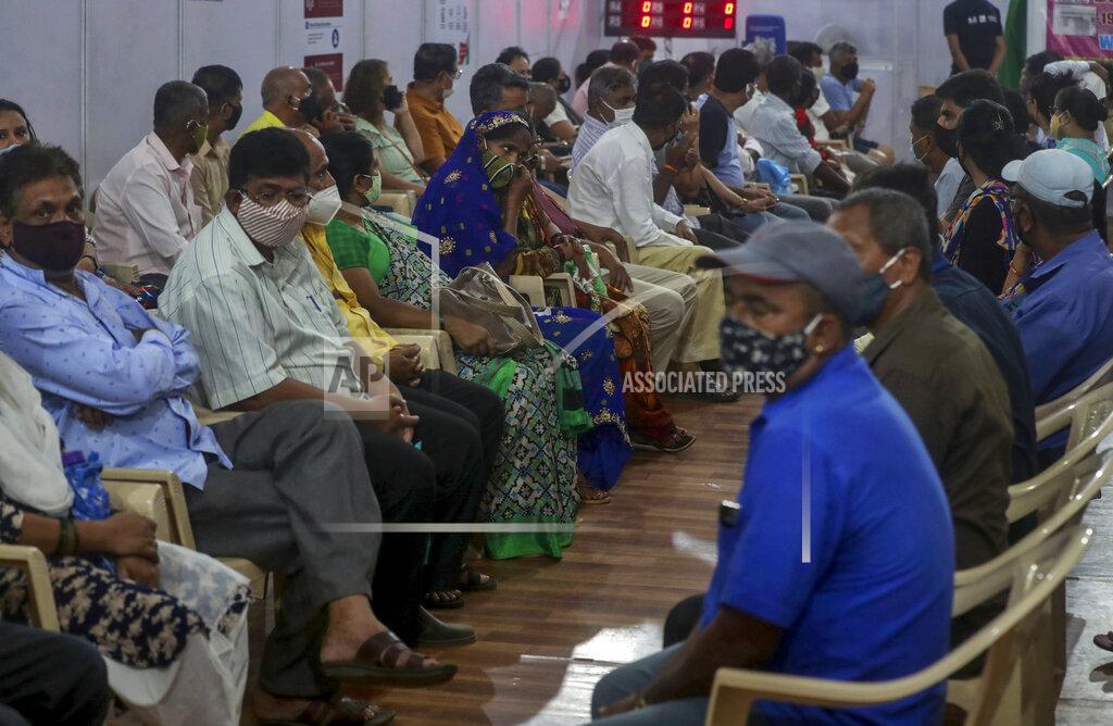 Rafiq Maqbool Indian's wait to receive vaccine for COVID-19 at a vaccination center in Mumbai, India, Sunday, April 18, 2021. Over 200,000 new infections were detected in the past 24 hours, and major cities, like Mumbai and New Delhi, are under virus restrictions. (AP Photo/Rafiq Maqbool)