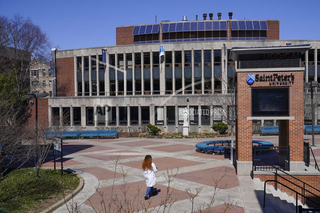 Seth Wenig A woman walks on the campus of St. Peter's University in Jersey City, N.J., Monday, March 21, 2022. (AP Photo/Seth Wenig)