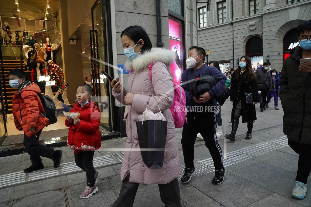 Ng Han Guan FILE - In this Jan. 14, 2021, file photo, residents, some wearing masks to protect themselves from the coronavirus, walk along a street in Wuhan in central China's Hubei province. One year after Wuhan’s lockdown to curb the coronavirus, the Chinese city has long since sprung back to life. (AP Photo/Ng Han Guan, File)