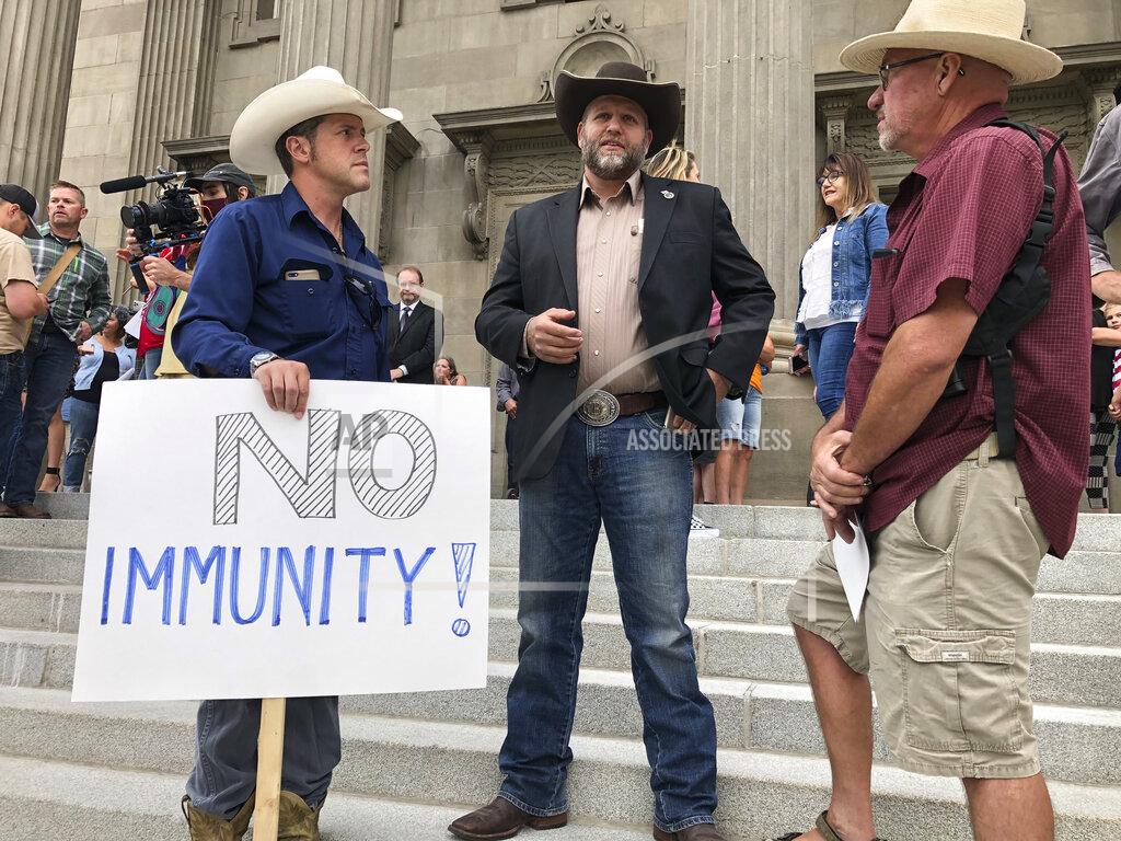Keith Ridler FILE - In this Aug. 24, 2020, file photo, Ammon Bundy, center, who led the Malheur National Wildlife Refuge occupation, stands on the Idaho Statehouse steps in Boise, Idaho. Mainstream and far-right Republicans are battling for control of the party and the state in deeply conservative Idaho. (AP Photo/Keith Ridler, File)