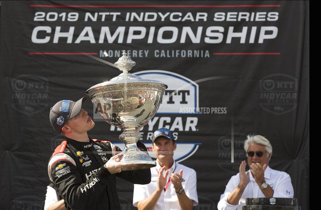 David Royal Josef Newgarden, left, kisses the trophy after winning the championship after an IndyCar auto race at Laguna Seca Raceway in Monterey, Calif., Sunday, Sept. 22, 2019. (AP Photo/David Royal)