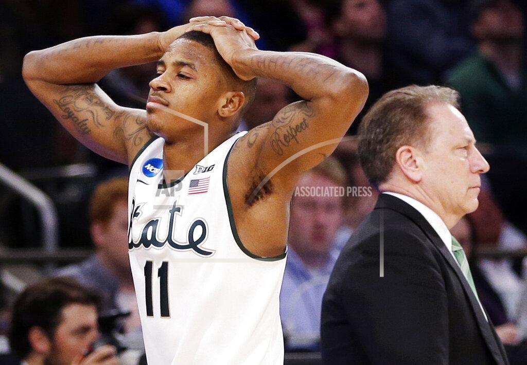Seth Wenig FILE - In this March 30, 2014, file photo, Michigan State's Keith Appling walks past head coach Tom Izzo in the closing minutes of their 60-54 loss to Connecticut in a regional final at the NCAA college basketball tournament in New York. Former Michigan State basketball player Appling faces drug charges after authorities say they found heroin in his vehicle that he planned to sell. Appling, on parole after serving jail time for gun and resisting-arrest charges, was arraigned Wednesday, Feb. 12, 2020, in a Warren courtroom on charges of delivery or manufacture of less than 50 grams of a controlled substance. (AP Photo/Seth Wenig, File)