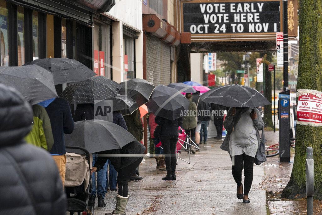 Mark Lennihan FILE - In this Oct. 30, 2020, file photo, people under umbrellas line up for early voting in the Brooklyn borough of New York. The 2020 presidential election had all the makings of a looming disaster: fears of Russian meddling, violence at the polls, voter intimidation and poll workers fleeing their posts over the coronavirus. But the election was largely smooth, in large part because 107 million voters that cast their ballots early and took the pressure off Election Day operations. (AP Photo/Mark Lennihan, File)