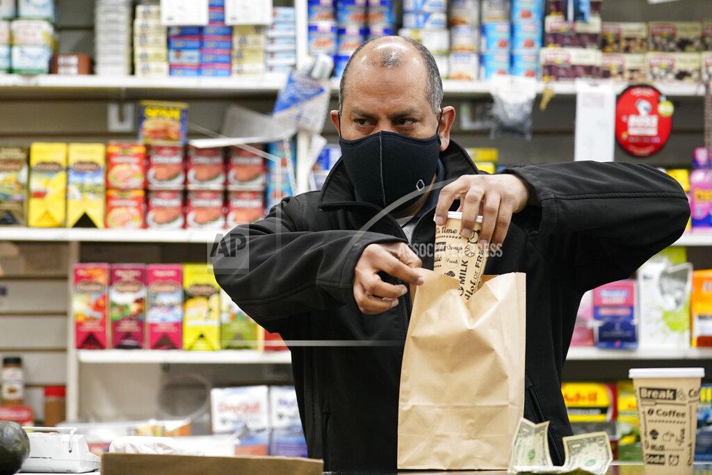 Kathy Willens Bodega owner Francisco Marte prepares coffee for a customer, Wednesday, Feb. 10, 2021, at his store in the Bronx borough of New York. Marte, president of the Bodega and Small Business Association of New York, said he has been lobbying local officials to set aside appointments for bodega workers, many of whom are unaware they are eligible. He hopes that the recent opening of a large vaccination site at Yankee stadium will make access easier. (AP Photo/Kathy Willens)