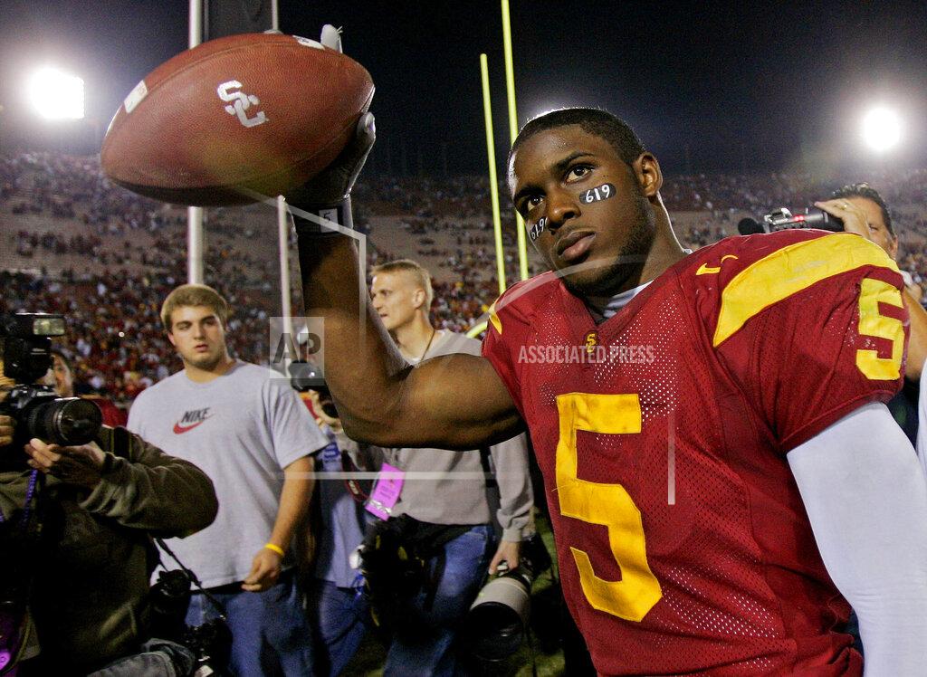Kevork Djansezian FILE - In this Nov. 19, 2005, file photo, Southern California tail back Reggie Bush walks off the field holding the game ball after the Trojans defeated Fresno State, 50-42, at the Los Angeles Coliseum. USC set a record by going 33 straight polls as No. 1 from 2003-05. The Trojans weren’t just the best team in college football, they were also arguably the coolest, with the charismatic, laid-back Carroll leading stars like quarterback Matt Leinart and running back Reggie Bush to victory after victory. (AP Photo/Kevork Djansezian, File)
