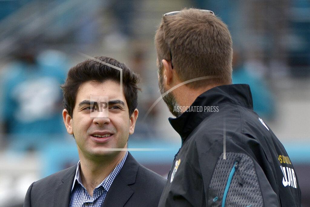 Phelan M. Ebenhack FILE - In this Dec. 15, 2013, file photo, Jacksonville Jaguars senior vice president Tony Khan, left, talks with an unidentified person prior to an NFL football game against the Buffalo Bills in Jacksonville, Fla. Disgruntled Jacksonville Jaguars defensive end Yannick Ngakoue goaded minority owner Tony Khan into a Twitter exchange Monday, April 20, 2020, in hopes of escalating his public trade demand. It may have backfired.(AP Photo/Phelan M. Ebenhack, File)