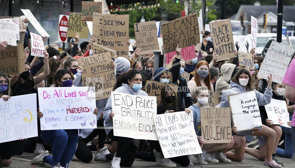 Protesters hold signs at the corner of Chicago Ave. and Washington Street in Naperville, Ill., Monday, June 1, 2020. Protests were held throughout the country over the death of George Floyd, a black man who died after being restrained by Minneapolis police officers on May 25. (Mark Welsh/Daily Herald, via AP)
