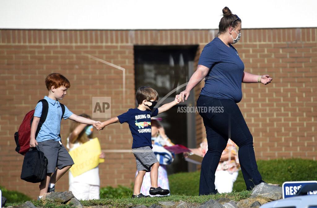 Michael Holahan Kids are led to Blue Ridge Elementary School for the first day of classes in Evans, Ga., Monday morning, Aug. 3, 2020. (Michael Holahan/The Augusta Chronicle via AP)