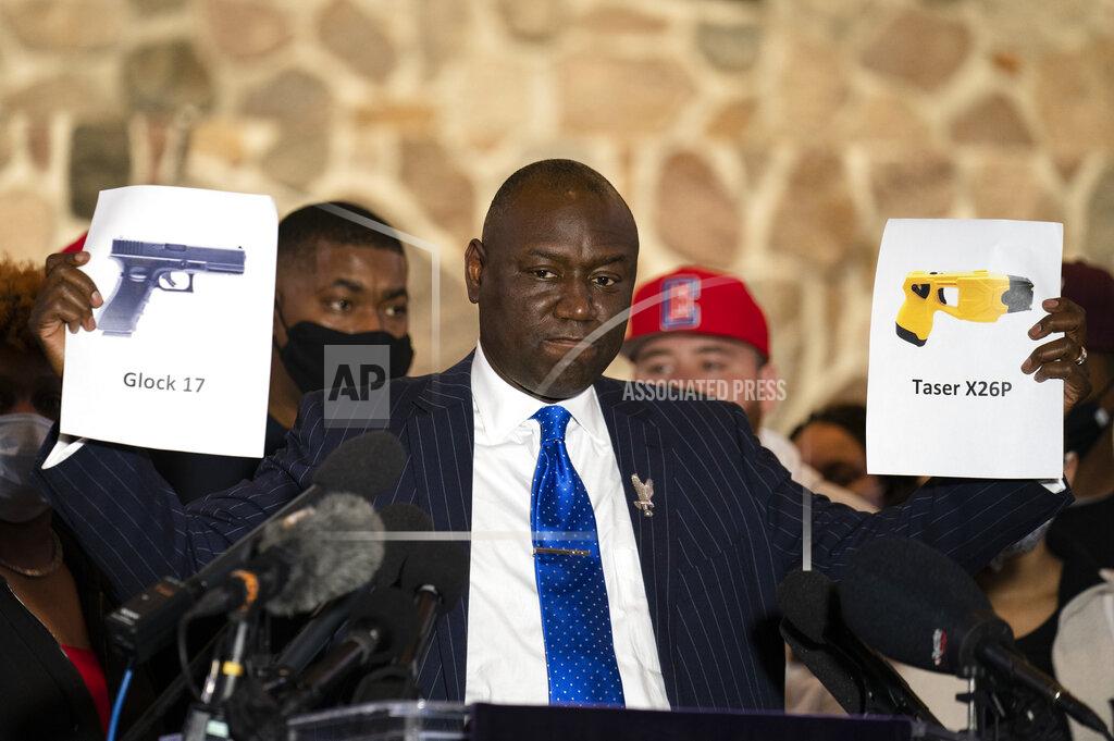 John Minchillo FILE - In this Thursday, April 15, 2021 file photo, attorney Ben Crump, representing the family of Daunte Wright, holds up images depicting an X26P Taser and a Glock 17 handgun during a news conference at New Salem Missionary Baptist Church in Minneapolis. (AP Photo/John Minchillo)