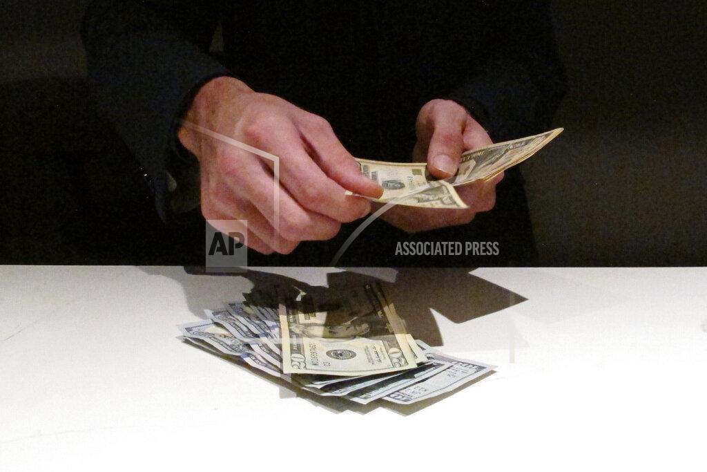Wayne Parry FILE — In this June 27, 2019 file photo, a clerk counts money at a sportbook, in Atlantic City, N.J. New Jersey's top gambling regulator is threatening to fine sports books operating in his state that ask customers to cancel requests to cash out money from their accounts, saying the practice is ongoing and "unacceptable." (AP Photo/Wayne Parry, File)