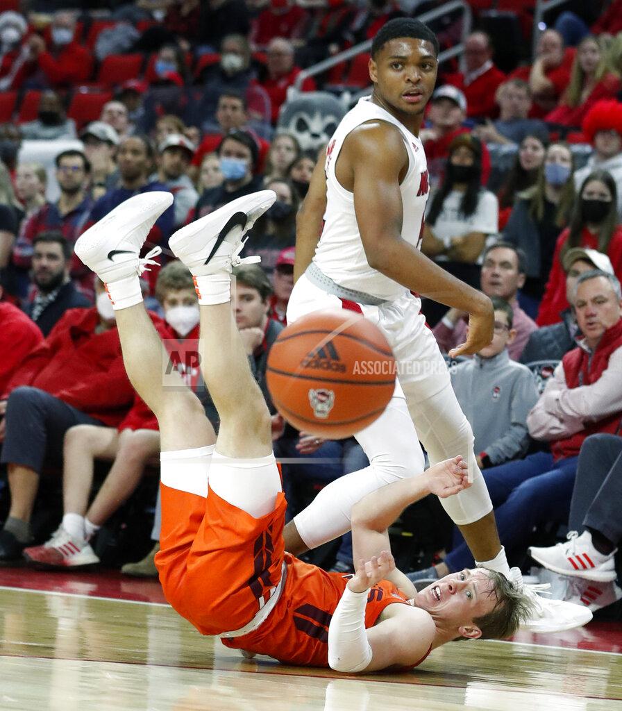 Ethan Hyman Virginia Tech's Storm Murphy (5) and North Carolina State's Casey Morsell (14) look at the loose ball after chasing after it during the first half of an NCAA college basketball game in Raleigh, N.C., Wednesday, Jan. 19, 2022. (Ethan Hyman/The News & Observer via AP)
