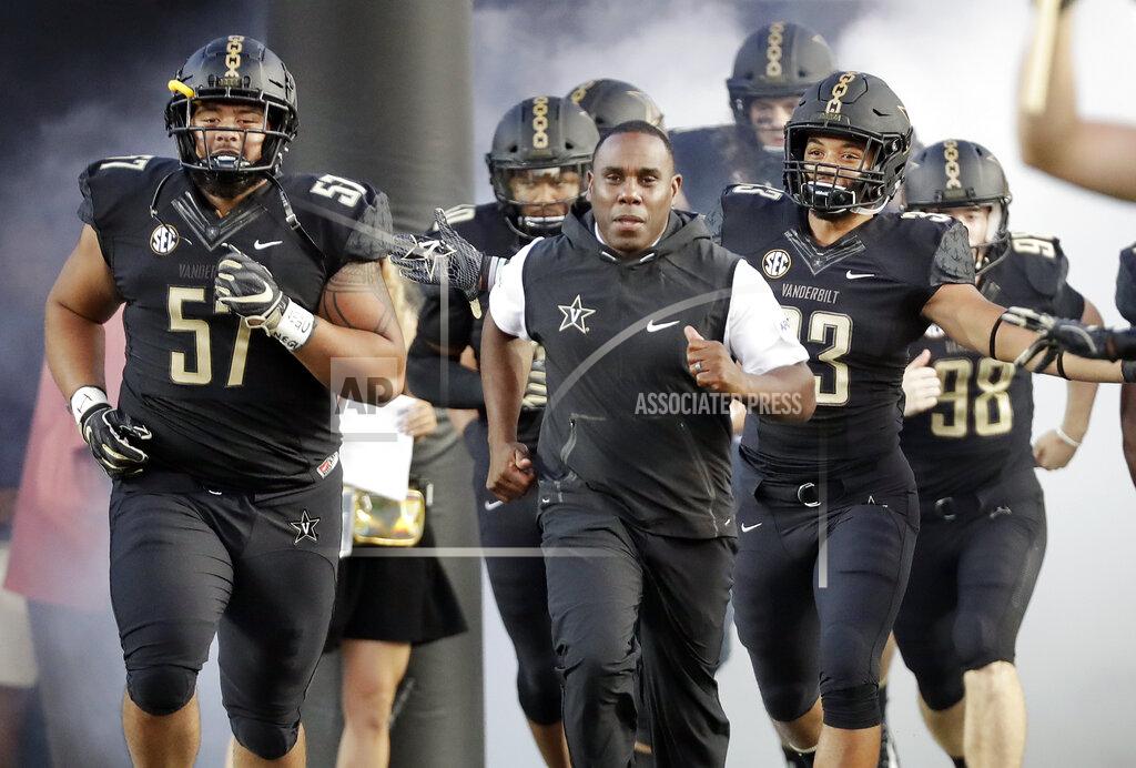 FILE - In this Sept. 1, 2018, file photo, Vanderbilt coach Derek Mason, center, runs onto the field with his team before its opening game of the NCAA college football season, against Middle Tennessee, in Nashville, Tenn. New Vanderbilt athletic director Malcolm Turner has extended the contract for coach Derek Mason after the Commodores reached a second bowl game in three seasons. Turner also announced Friday, Feb. 22, 2019, extensions for men’s golf coach Scott Limbaugh and bowling coach John Williamson.(AP Photo/Mark Humphrey, File)