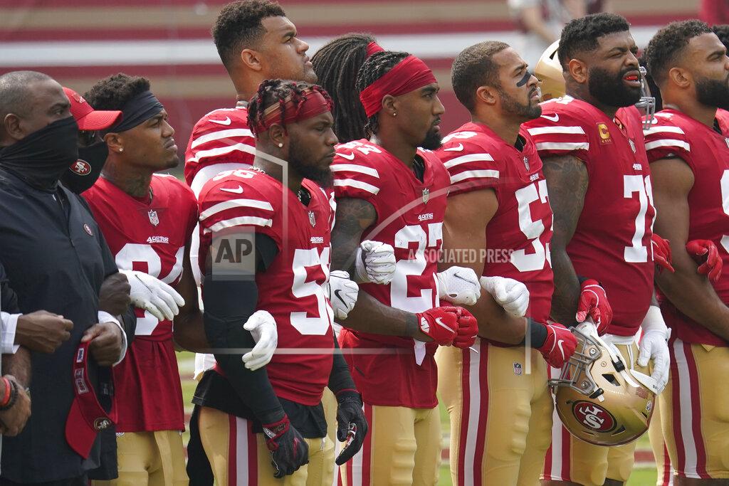 Tony Avelar San Francisco 49ers players and coaches lock arms while standing during a presentation on social justice before an NFL football game against the Arizona Cardinals in Santa Clara, Calif., Sunday, Sept. 13, 2020. (AP Photo/Tony Avelar)
