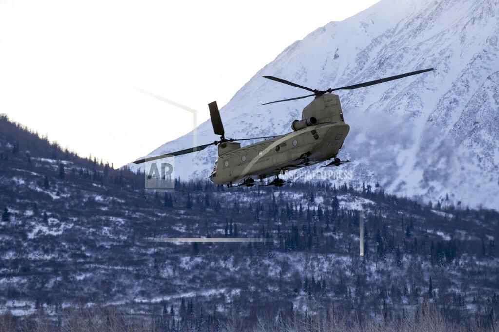 In this photo provided by the Alaska National Guard, a CH-47 Chinook helicopter departs Bryant Army Airfield, Dec. 11, 2020, on its way to Nanwalek, Alaska, to deliver Christmas gifts to the children of the village for Operation Santa Claus 2020. The Alaska National Guard and the Salvation Army were able to provide and deliver gifts for the program's 65th year, but had to scale back distribution parties that are normally held in the villages because of COVID-19. (Spc. Grace Nechanicky/U.S. Army National Guard via AP)