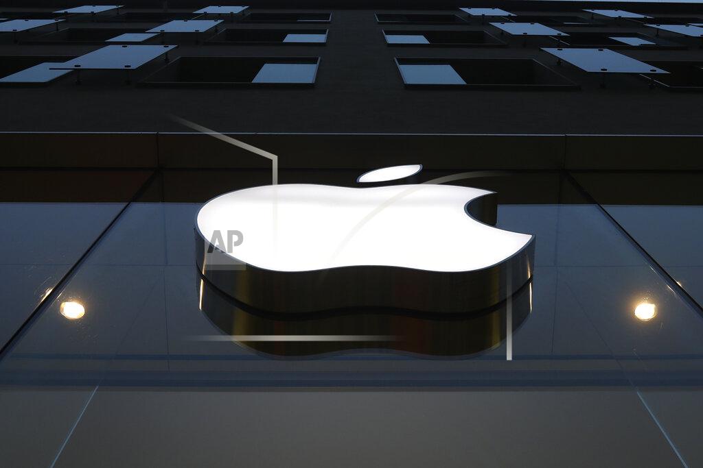 The logo of Apple is illuminated at a store in the city center in Munich, Germany, Wednesday, Dec. 16, 2020. Apple’s delayed launch of its latest iPhones unleashed a holiday buying frenzy that propelled sales of the trendsetting company’s most popular product to its fastest start in years. The apparently pent-up demand for four different iPhone 12 models highlighted Apple’s latest quarterly report Wednesday, Jan. 27, 2021. (AP Photo/Matthias Schrader)