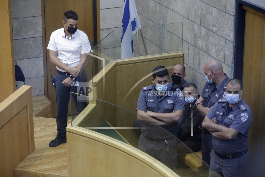 Sebastian Scheiner Yakub Kadari is surrounded by guards in a courtroom in Nazareth, Israel, after he and three other Palestinian fugitives were captured on Saturday, Sept. 11, 2021. Israeli police on Saturday said they have arrested four of the six Palestinians who broke out of a maximum-security prison this week — including a famed militant leader whose exploits over the years have made him a well-known figure in Israel. (AP Photo/Sebastian Scheiner)
