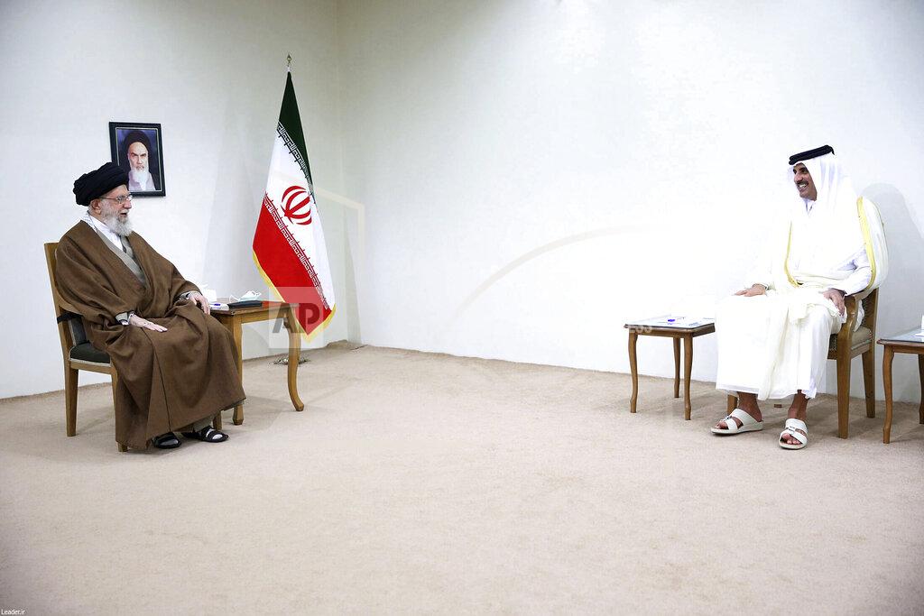Uncredited In this picture released by the official website of the office of the Iranian supreme leader, Supreme Leader Ayatollah Ali Khamenei, left, speaks with Qatari Emir Sheikh Tamim bin Hamad Al Thani in Tehran, Iran, Thursday, May, 12, 2022. A portrait of the late Iranian revolutionary founder Ayatollah Khomeini hangs on the wall at left. (Office of the Iranian Supreme Leader via AP)