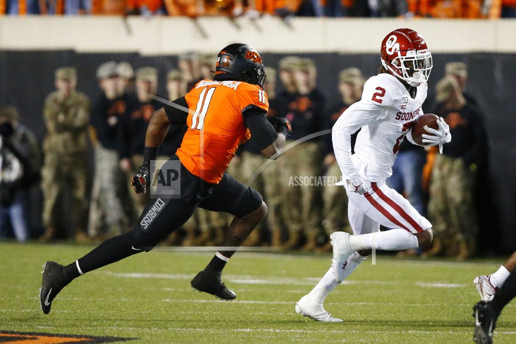 Sue Ogrocki Oklahoma wide receiver CeeDee Lamb (2) is chased by Oklahoma State linebacker Amen Ogbongbemiga (11) in the first half of an NCAA college football game in Stillwater, Okla., Saturday, Nov. 30, 2019. (AP Photo/Sue Ogrocki)