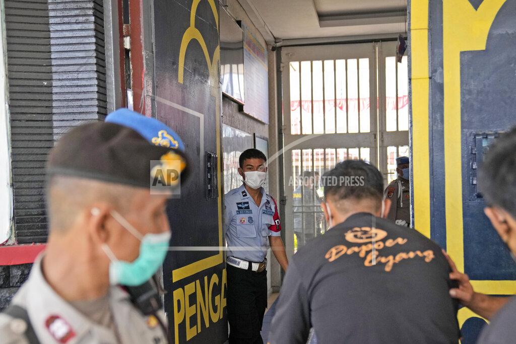 Dita Alangkara Staff and police officers guard the main entrance gate of Tangerang prison in Tangerang on the outskirts of Jakarta, Indonesia, Wednesday, Sept. 8, 2021. A massive fire raged through the overcrowded prison early Wednesday, killing a number of inmates. (AP Photo/Dita Alangkara)