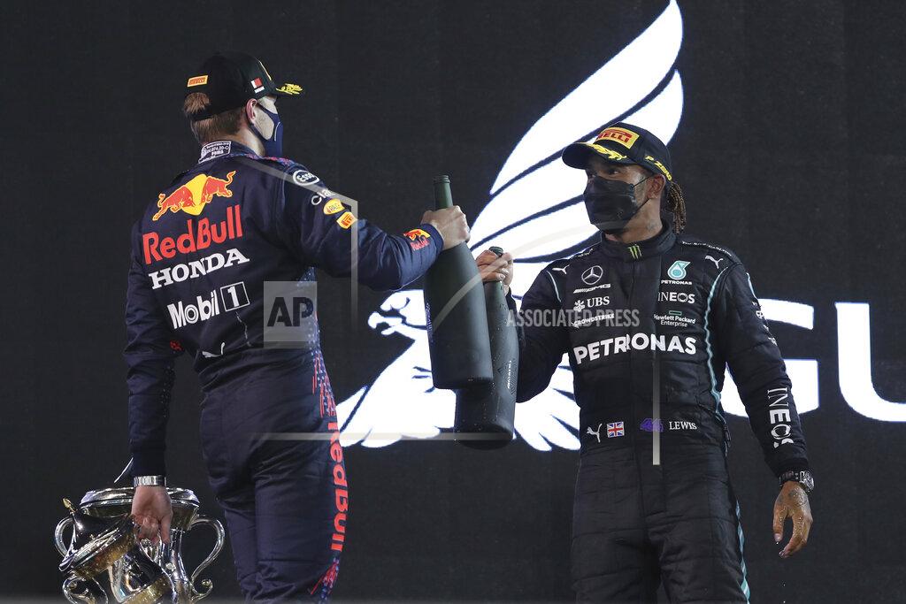 Kamran Jebreili Winner, Mercedes driver Lewis Hamilton of Britain, right, celebrates with Red Bull driver Max Verstappen of the Netherlands, second place, on the podium after the Bahrain Formula One Grand Prix at the Bahrain International Circuit in Sakhir, Bahrain, Sunday, March 28, 2021. (AP Photo/Kamran Jebreili)