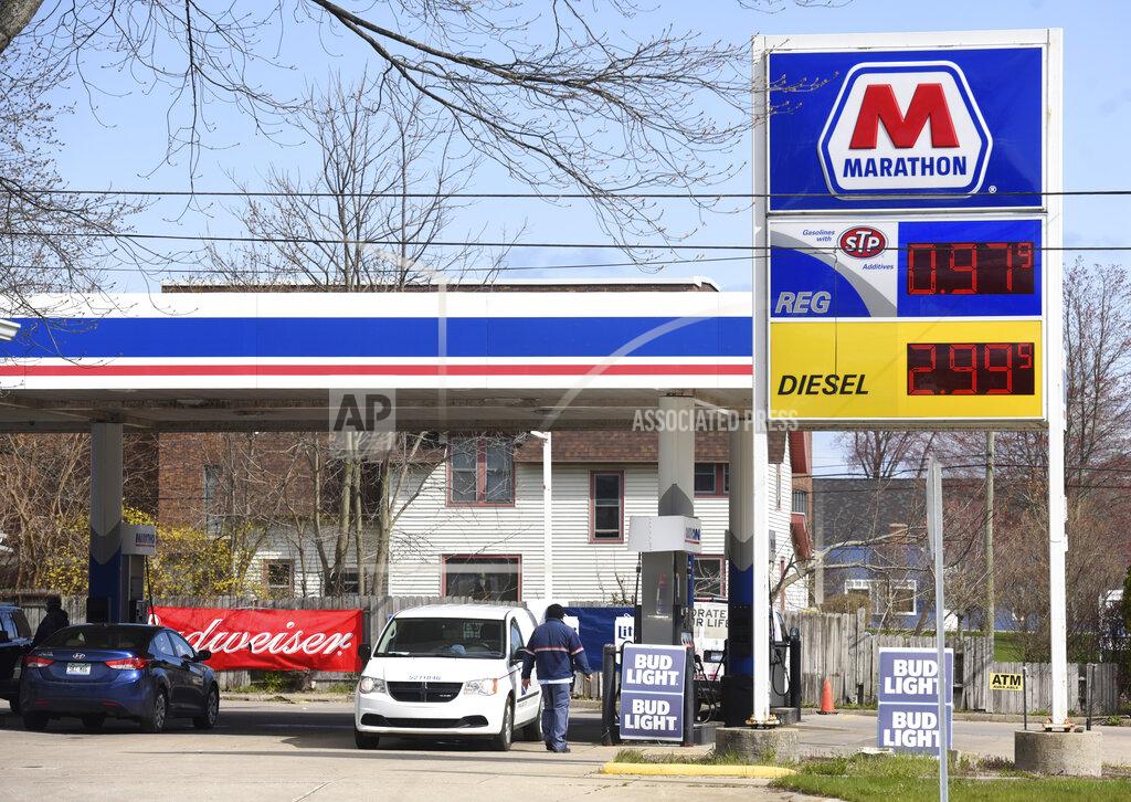 Don Campbell FILE - In this April 21, 2020 file photo, customers fill up their tanks at the Marathon gas station along Broadway Street in South Haven, Mich., as the price for regular unleaded falls below $1 a gallon. The outbreak of the coronavirus has dealt a shock to the global economy with unprecedented speed. Fill-ups at the pump fell 49% from 2019 volumes during the second week of April. (Don Campbell/The Herald-Palladium via AP, File)