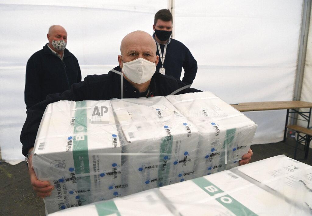 Noemi Bruzak An employee unloads the newly arrived coronavirus vaccines from Chinese pharmaceutical company Sinopharm at the logistics base set up to in the parking lot of the government office in the 13th district of Budapest, Hungary, Monday, March 29, 2021. (Noemi Bruzak/MTI via AP)