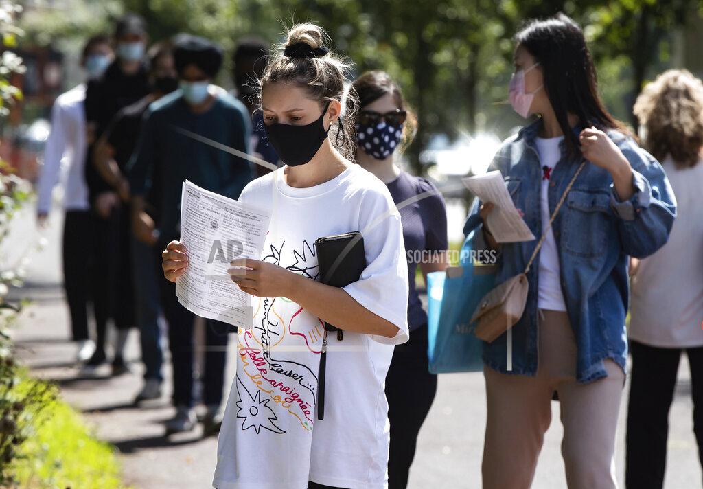 Darryl Dyck People wait in line at a COVID-19 testing facility during the coronavirus pandemic in Burnaby, British Columbia, on Thursday, Aug. 13, 2020. (Darryl Dyck/The Canadian Press via AP)