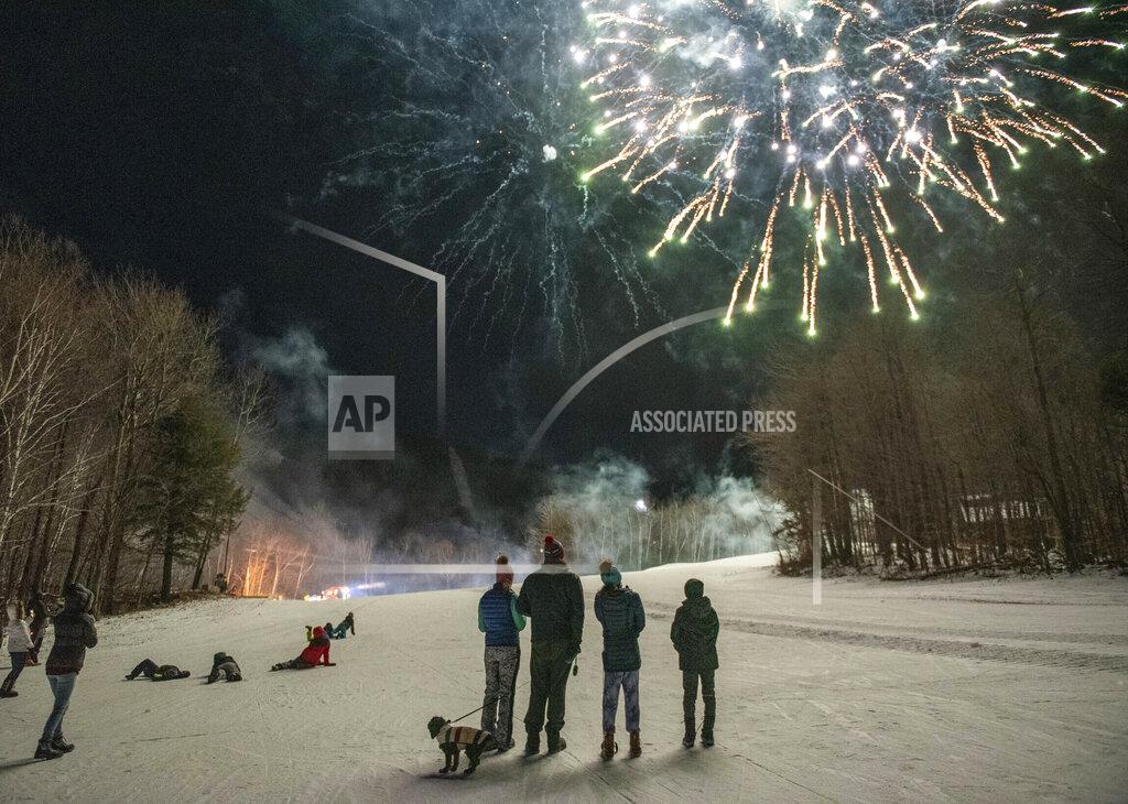 Andree Kehn Sunday River guests watch the fireworks display on the side of the ski trails to ring in the New Year, Thursday, Dec. 31, 2020 in Newry, Maine. All festivities stopped promptly at 9 PM in accordance with state guidelines. (Andree Kehn/Sun Journal via AP)