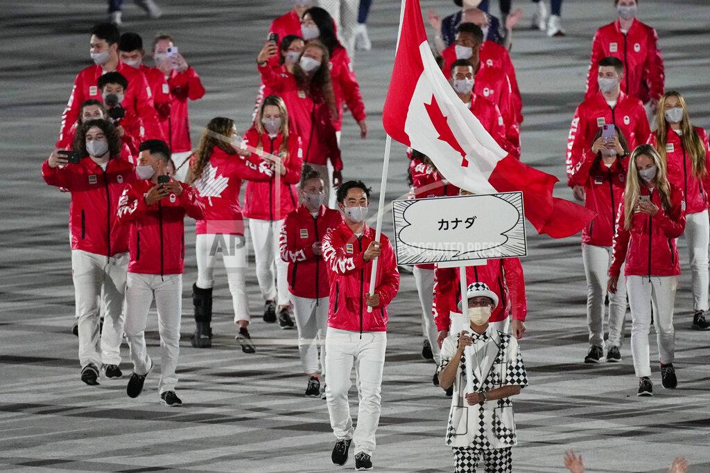 Miranda Ayim and Nathan Hirayama, of Canada, carry their country's flag during the opening ceremony in the Olympic Stadium at the 2020 Summer Olympics, Friday, July 23, 2021, in Tokyo, Japan. (AP Photo/David J. Phillip)