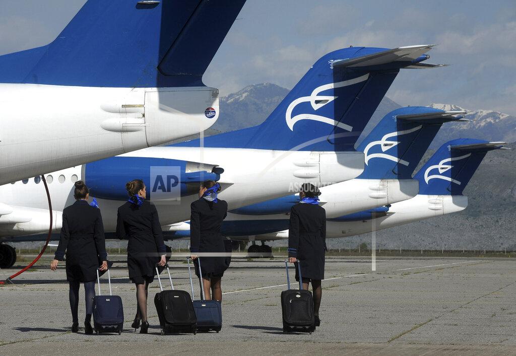 Risto Bozovic In this photo taken on April 10, 2014, Montenegro Airlines stewardesses walk to a plane on the tarmac at Golubovci airport, near Podgorica, Montenegro. Montenegro Airlines ceased its operations on Saturday, Dec. 26, 2020 after the small country's new government refused to continue financing the national carrier. The airline which was formed 25 years ago has apologized to its passengers for the sudden termination of all flights and thanked them for "the years of trust, travel and friendship." (AP Photo/Risto Bozovic)
