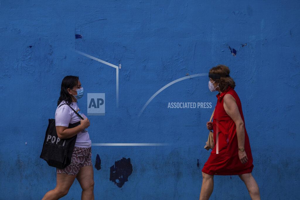 Bernat Armangue Two woman wearing face masks to prevent the spread of coronavirus walk in the southern neighbourhood of Vallecas in Madrid, Spain, Wednesday, Sept. 16, 2020. The Spanish capital will introduce selective lockdowns in urban areas where the coronavirus is spreading faster, regional health authorities announced on Tuesday. The measures in Madrid will most likely affect southern, working-class neighbourhoods where virus contagion rates have been steadily soaring since August. (AP Photo/Bernat Armangue)