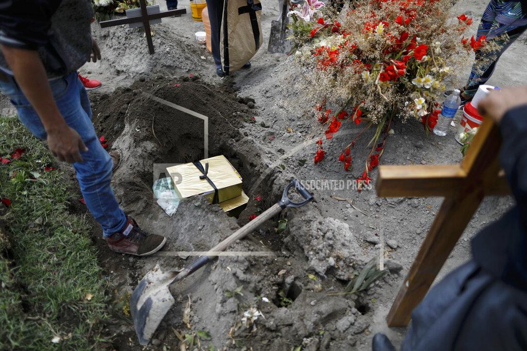 Rebecca Blackwell Boxes containing the flowers, lime and other symbolic elements used in the cross-raising ceremony are buried atop the grave of Luz Maria Gonzalez, as her family marks nine days since her burial, in the Municipal Cemetery of Valle de Chalco on the outskirts of Mexico City, Saturday, July 4, 2020. Maria Luz Gonzalez, 56, who had long suffered from asthma, diabetes and hypertension, died two days after her son, who was hospitalized for breathing problems and a cough before dying of complications said to be related to pneumonia and undiagnosed diabetes. (AP Photo/Rebecca Blackwell)