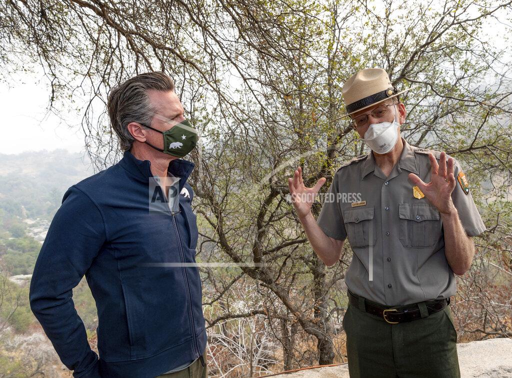 Ron Holman California Gov. Gavin Newsom, left, and Superintendent of Sequoia and Kings Canyon National Parks Clay Jordan talk Thursday, Sept. 23, 2021, in Sequoia National Park, Calif., after Newsom signed a climate package into law. California Gov. Gavin Newsom on Thursday approved nearly $1 billion in new spending to prevent wildfires, signaling a policy shift in a state that historically focused more on putting out fires than stopping them before they start. (Ron Holman/The Times-Delta via AP)