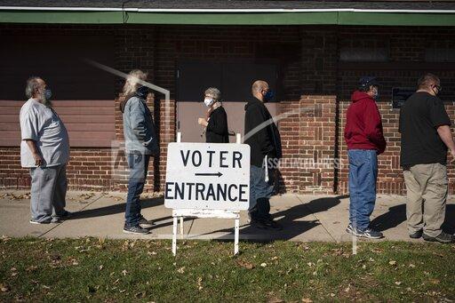 FILE - Voters wait in line outside a polling center on Election Day, in Kenosha, Wis. in this Nov. 3, 2020 file photo. Wisconsin Republicans are working to discredit the bipartisan system they created to run elections in the state after President Joe Biden narrowly won last year's presidential race, making the political battleground state the latest front in the national push by the GOP to exert more control over elections. (AP Photo/Wong Maye-E, File)