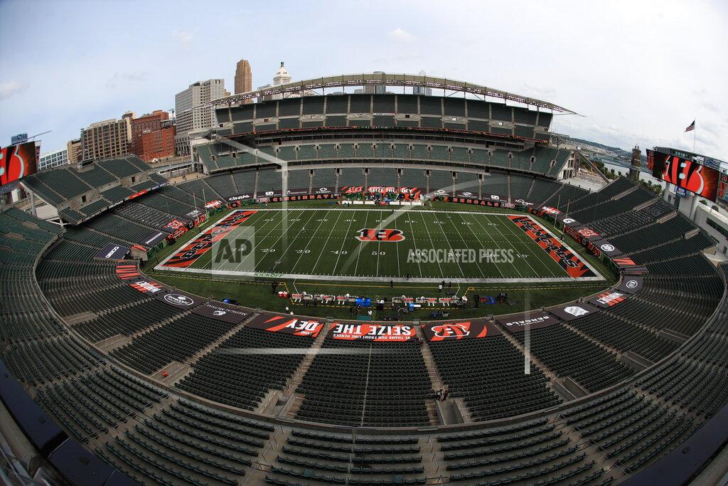 Aaron Doster FILE—In this file photo from Sept. 13, 2020, players walk out to the field before at Paul Brown stadium that is devoid of fans to start warming up before an NFL football game between the Cincinnati Bengals and the Los Angeles Chargers, in Cincinnati. Ohio Gov. Mike DeWine has issued a warning against Ohioans gathering for big events like weddings and funerals, while defending a decision to boost the number of fans allowed to attend NFL games in the state. The governor also said Thursday, Oct. 8, 2020 that even as cases rise in the state, the economy won't be shut down again. (AP Photo/Aaron Doster)