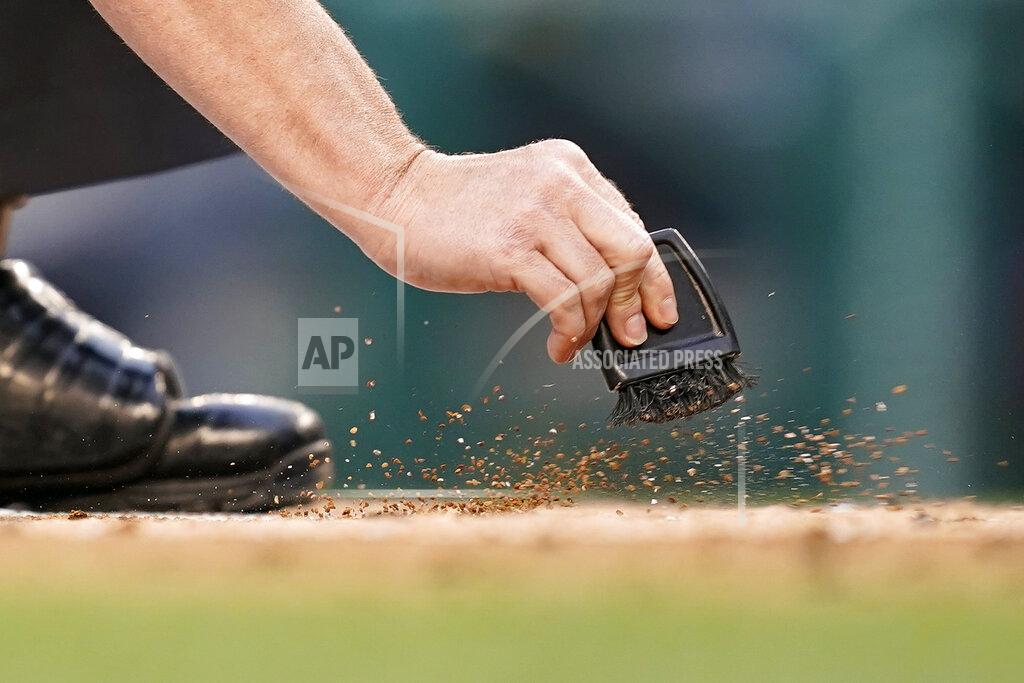 Patrick Semansky Home plate umpire Sean Barber sweeps dirt from home plate in the first inning of a baseball game between the Colorado Rockies and the Washington Nationals, Thursday, May 26, 2022, in Washington. (AP Photo/Patrick Semansky)