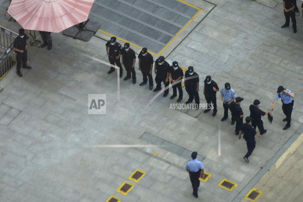 Ng Han Guan Police officers and security guards prepare for duty outside the headquarters for Evergrande in Shenzhen in southern China, Thursday, Sept. 23, 2021. The Chinese real estate developer whose struggle to avoid defaulting on billions of dollars of debt has rattled global markets says it will pay interest due Thursday to bondholders in China but gave no sign of plans to pay on a separate bond abroad. (AP Photo/Ng Han Guan)