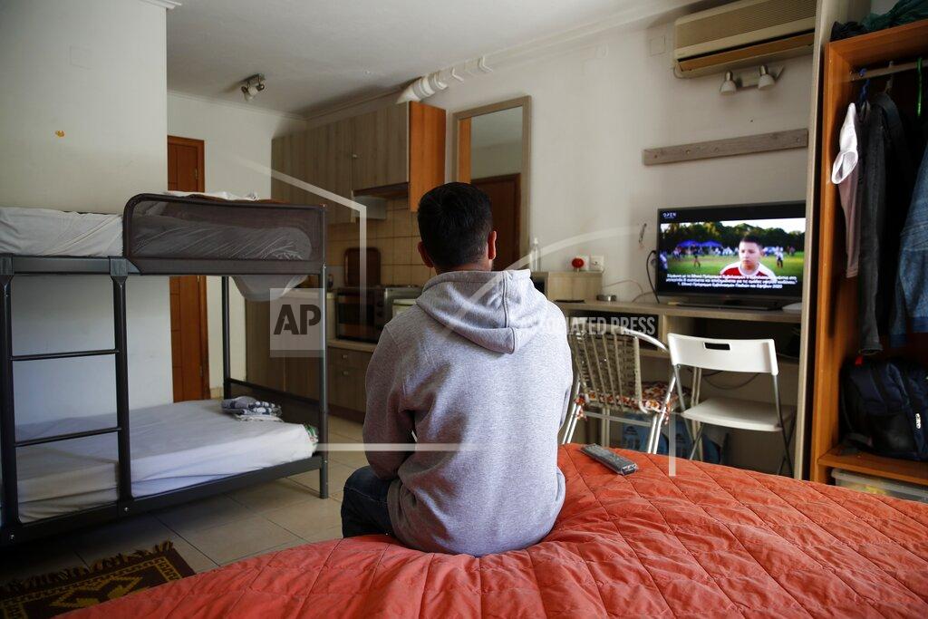 Thanassis Stavrakis An Afghan father watches television in his room, at the port of Vathy on the eastern Aegean island of Samos, Greece, Wednesday, Feb. 24, 2021. On a hill above a small island village, the sparkling blue of the Aegean just visible through the pine trees, lies a boy’s grave. His first ever boat ride was to be his last - the sea claimed him before his sixth birthday. His 25-year-old father, like so many before him, had hoped for a better life in Europe, far from the violence of his native Afghanistan. But his dreams were dashed on the rocks of Samos, a picturesque Greek island almost touching the Turkish coast. Still devastated from losing his only child, the father has now found himself charged with a felony count of child endangerment. (AP Photo/Thanassis Stavrakis)